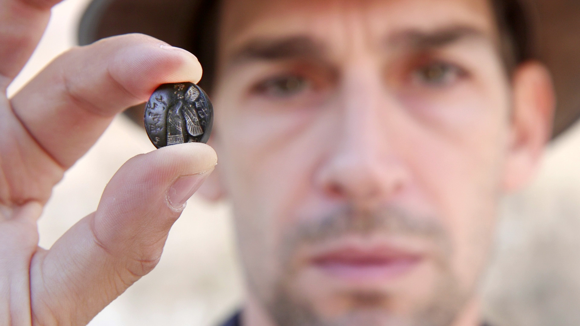 Il direttore degli scavi Rom Navot con il sigillo (foto: Emil Aladjem, Israel Antiquities Authority)